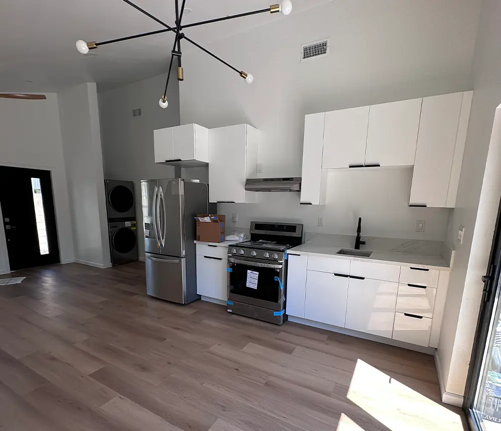 Home addition with vinyl floor and white kitchen cabinets