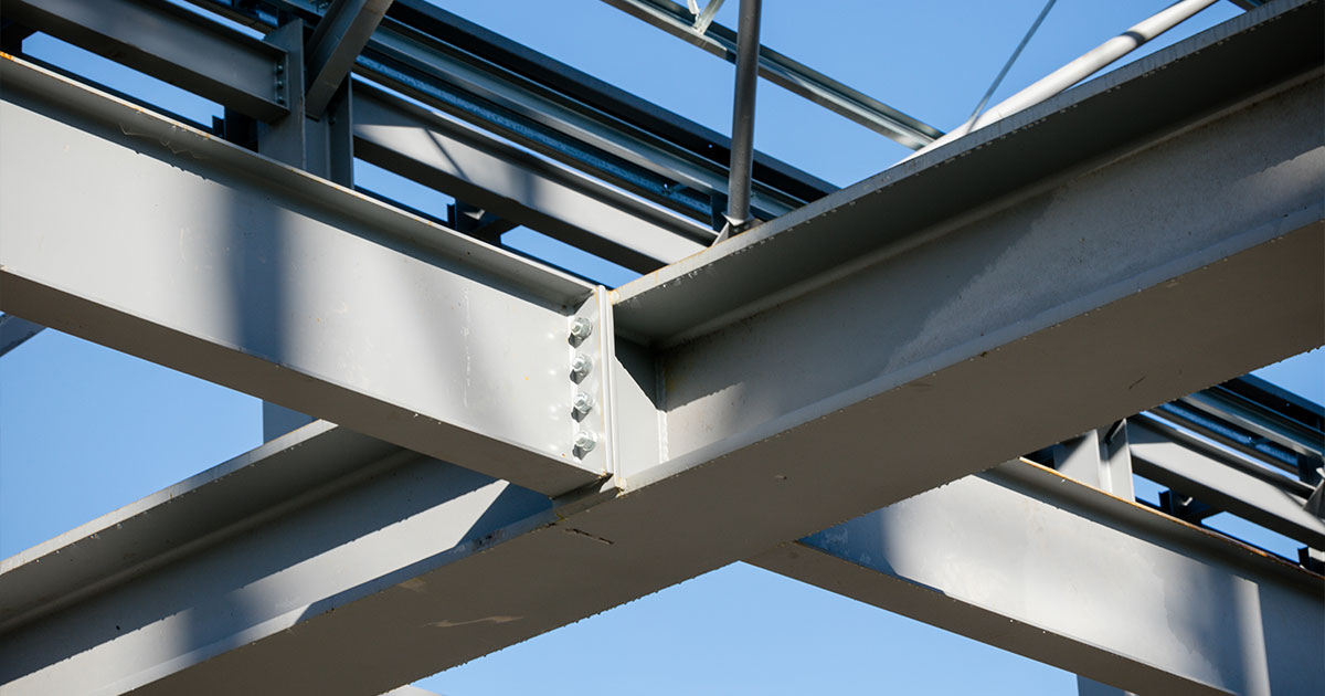 Close-up of steel beams in a modern building's structural framework, highlighting metal construction techniques.