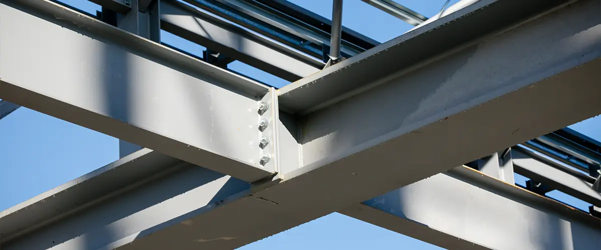 Close-up of steel beams in a modern building's structural framework, highlighting metal construction techniques.