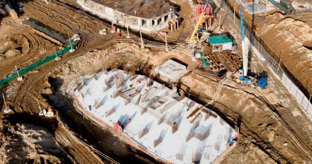 Aerial view of a construction site with foundation work in progress and heavy machinery