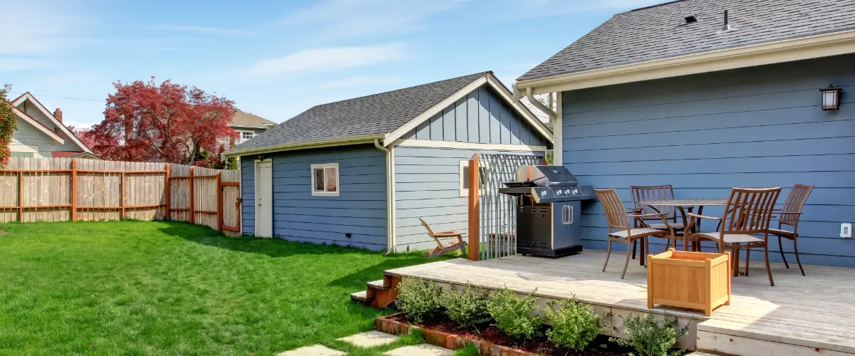 a backyard featuring a main house and a separate, smaller structure, which is commonly referred to as an accessory dwelling unit (ADU)