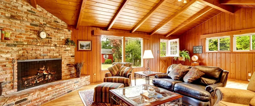 home additions accessory dwelling unit adu floor plan spacious living room with brick fireplace wood paneling leather sofa and large windows
