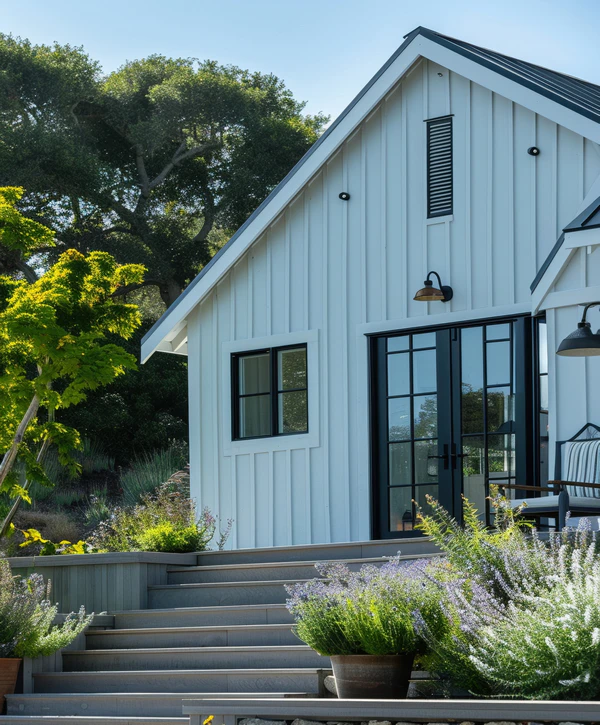 A modern white board and batten accessory dwelling unit in Rancho Palos Verdes, CA featuring black trimmed windows and a grey wood deck.