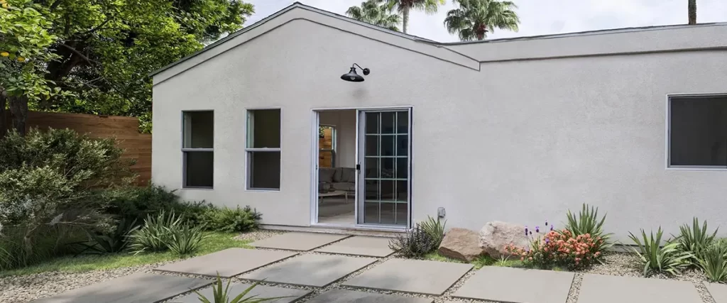 New stucco home addition with modern landscaping, sliding glass door, and minimalist architecture